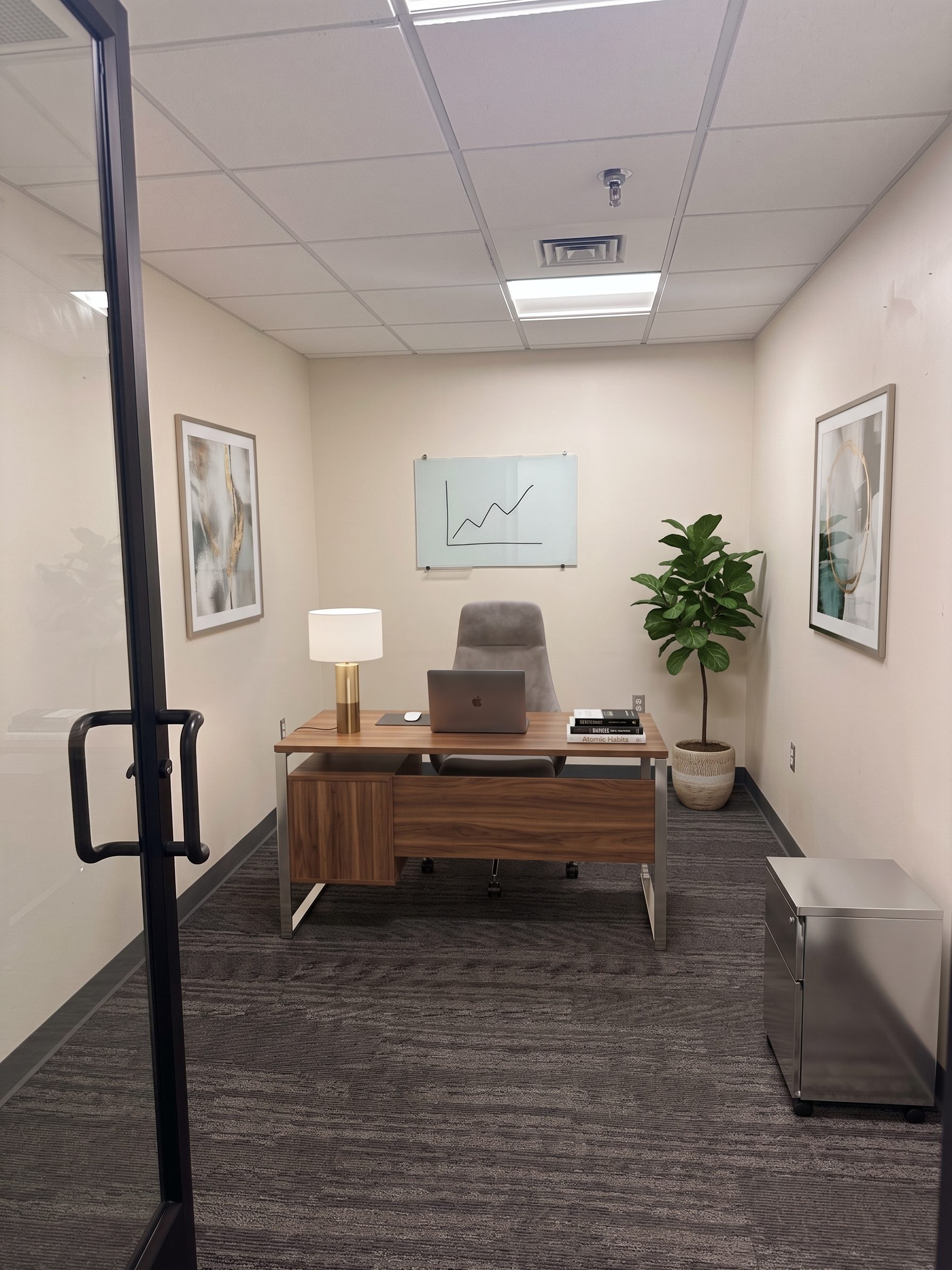 Suite 213 at 750 Main, shown virtually staged with a desk, chair, and plant
